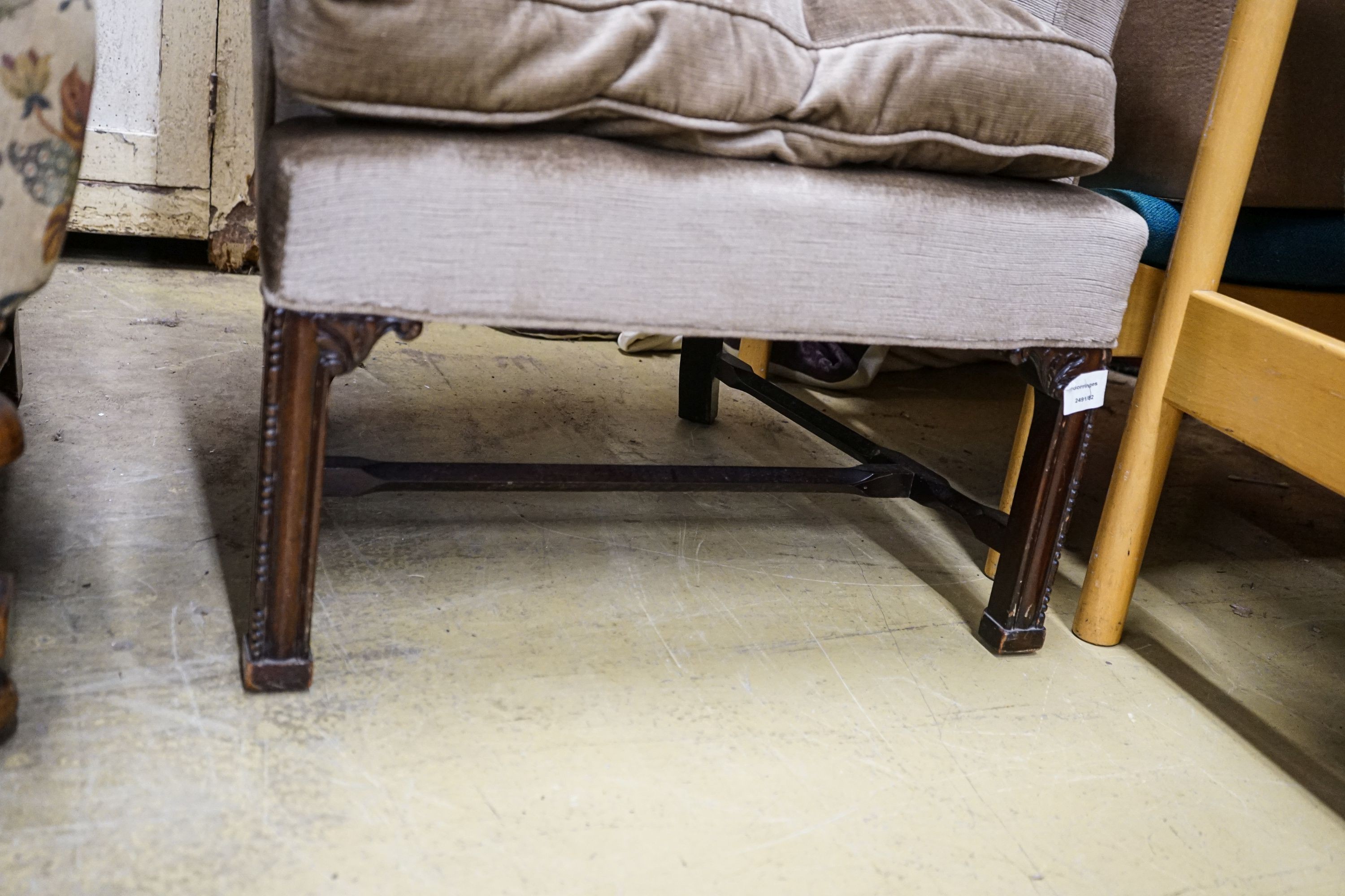 A George III style mahogany wing armchair, with carved squared legs, width 79cm, depth 60cm, height 101cm